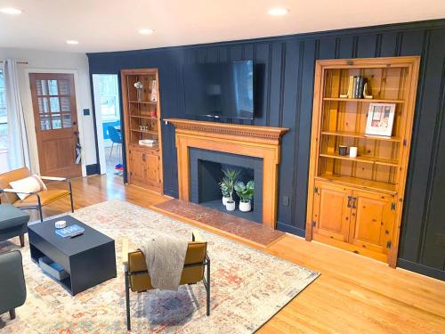 a living room with a fireplace and a table and chairs at Renovated Modern Home Minutes to Downtown Richmond in Richmond