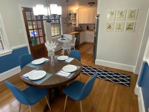 a dining room with a wooden table and blue chairs at Renovated Modern Home Minutes to Downtown Richmond in Richmond