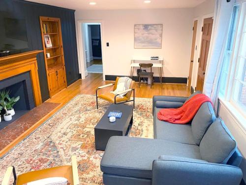 a living room with a blue couch and a fireplace at Renovated Modern Home Minutes to Downtown Richmond in Richmond
