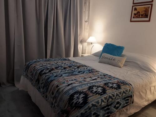 a bed with a pillow on top of it at Caleta Austral - dptos in Las Grutas
