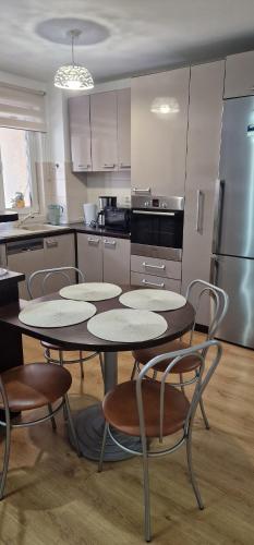 a kitchen with two tables and chairs and a refrigerator at DD's place in Sibiu
