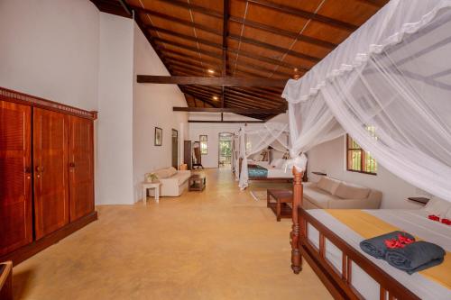 a bedroom with a bed and a living room at Nos Da Ty Hotel in Ahangama