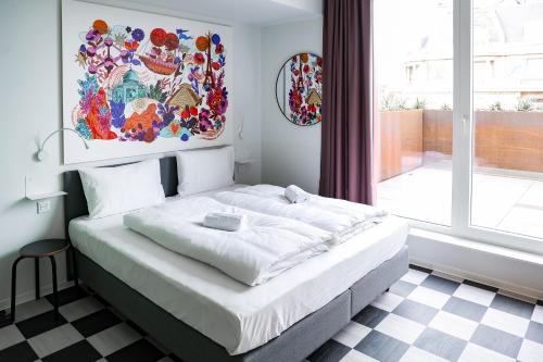 a bedroom with a white bed with a checkered floor at BX Downtown - Brussels in Brussels