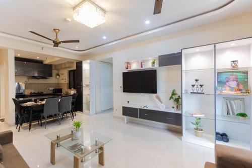 a living room with a television and a dining room at Indigo Studio by JadeCaps 1BHK New Town Kolkata in kolkata