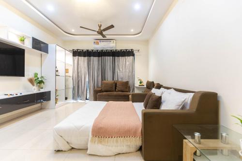 a large bedroom with a bed and a couch at Indigo Studio by JadeCaps 1BHK New Town Kolkata in kolkata