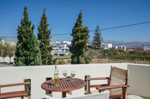 a table with two glasses of wine on a balcony at Perla Hotel in Agios Prokopios