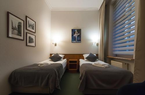 a room with two beds and a window at Hotel Polonia Racibórz in Racibórz