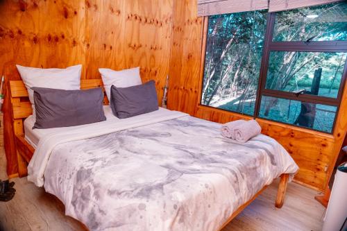 a bedroom with a bed in a wooden cabin at Falcon Lodge Bela Bela in Bela-Bela