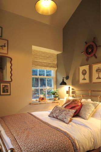 a bedroom with a large bed with a window at Lock Keepers Cottage at Salterhebble in Exley