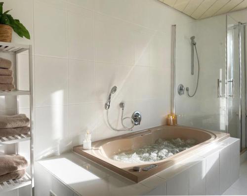 a large tub in a bathroom with a shower at green rooms in Schweinfurt