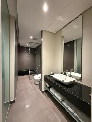 a bathroom with a sink and a toilet and a mirror at Rafa Hotel Apart in Riyadh