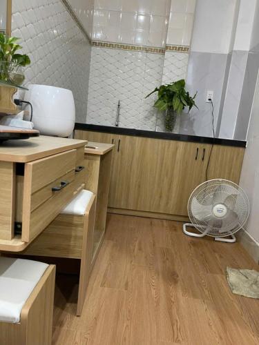 a kitchen with a desk and a fan on the floor at LAKSHMI Apartment & Hotel Da Nang in Danang