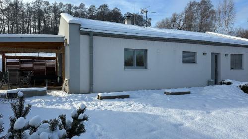 a white house with snow in front of it at Apartmán 135 in Trutnov