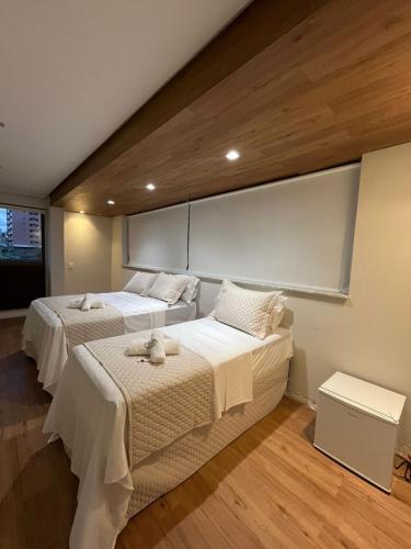 ein Schlafzimmer mit zwei Betten mit weißer Bettwäsche in der Unterkunft Murano Suits Hotel in João Pessoa
