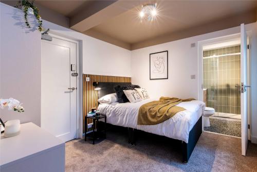 a bedroom with a bed and a bathroom at The Coach House, Gatwick in Horley