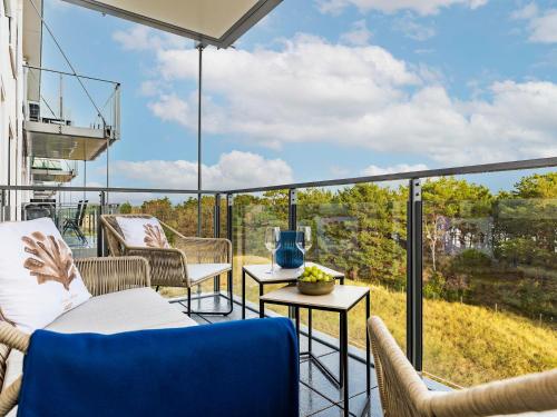 a patio with chairs and tables on a balcony at Prora - Apartment mit Strandnähe - Aquarius in Binz