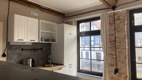 a kitchen with white cabinets and a window at Kleine Auszeit in Oderberg