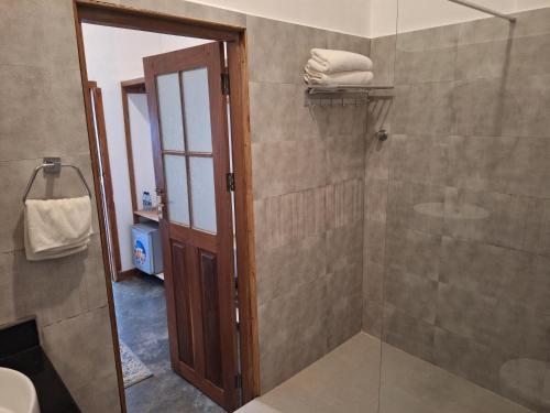 a bathroom with a shower with a glass door at The Archipelago Waterfront in Zanzibar City