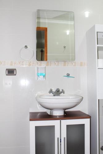 a bathroom with a sink and a mirror at Residencial Victoria Said in Linares