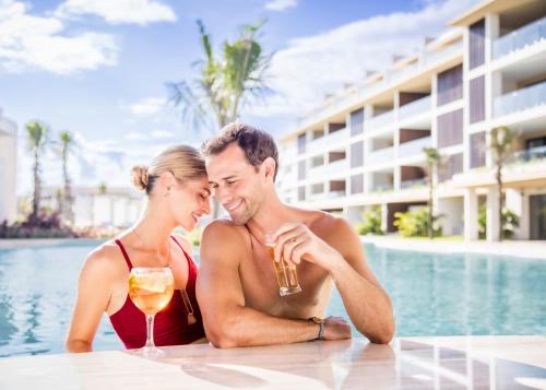 a man and a woman sitting at a table with drinks at Majestic Mirage Costa Mujeres, All Suite Resort - All Inclusive in Cancún