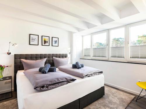 a white bedroom with a large bed with two pillows at Prora - Ferienwohnung mit Waschmaschine - Sunrise in Binz