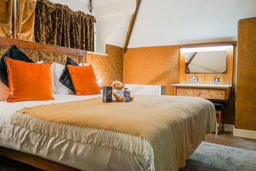 a teddy bear sitting on a bed in a room at The Cranleigh Boutique in Bowness-on-Windermere