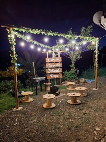 a group of picnic tables and a sign with lights at Cabaña Campestre Bellavista in Paipa