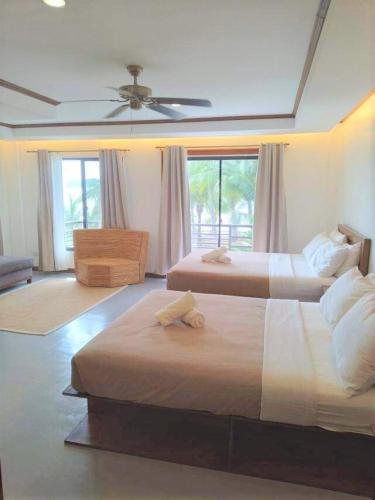 a bedroom with two beds and a ceiling fan at Anapuro Elnido in El Nido