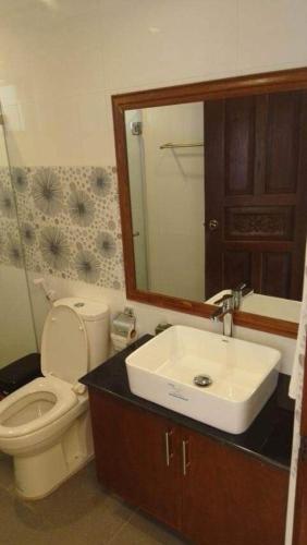 a bathroom with a toilet and a sink and a mirror at Anapuro Elnido in El Nido