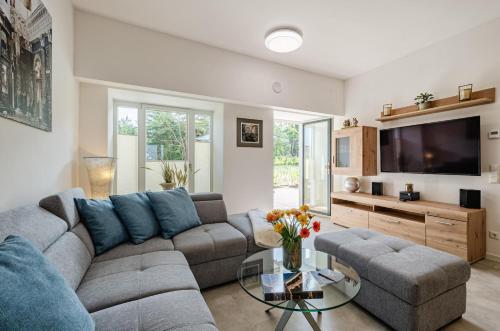 a living room with a couch and a tv at Prora - Wohnung mit Terrasse - Proras Strandhaus in Binz