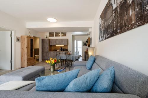 a living room with a gray couch and blue pillows at Prora - Wohnung mit Terrasse - Proras Strandhaus in Binz