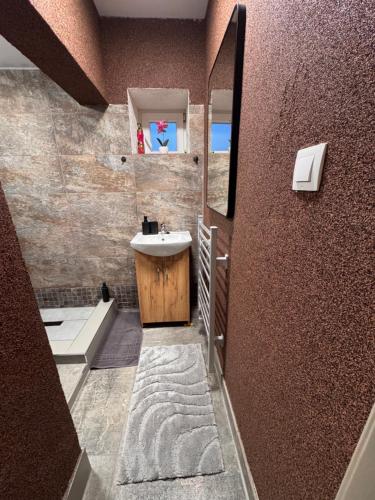 a bathroom with a sink and a mirror at JB apartments in Liptovský Mikuláš
