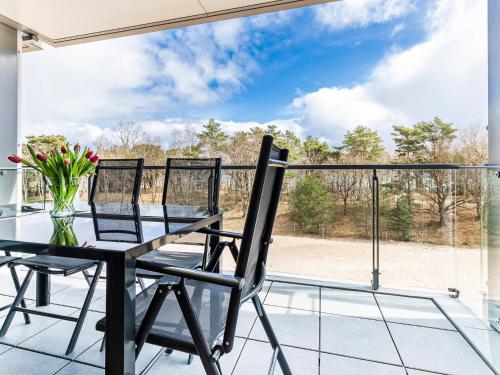 a balcony with a glass table with flowers on it at Prora - Ferienwohnung mit Balkon und Waschmaschine - Dünenheide 3,3 in Binz