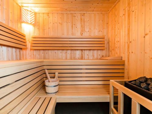 a wooden sauna with a bucket in it at Prora - Ferienwohnung mit Balkon und Waschmaschine - Dünenheide 3,3 in Binz