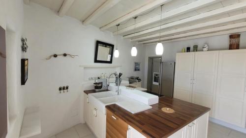 a bathroom with white walls and a sink and a counter at Villa Mikro Chorio in Kóstos