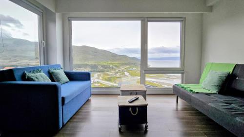 a living room with two couches and a large window at Turek Residences in Ushuaia