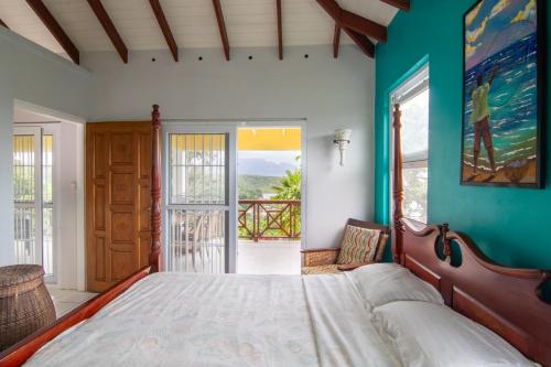 a bedroom with a bed and a view of the ocean at La Caye - Ocean View Villa in Calibishie