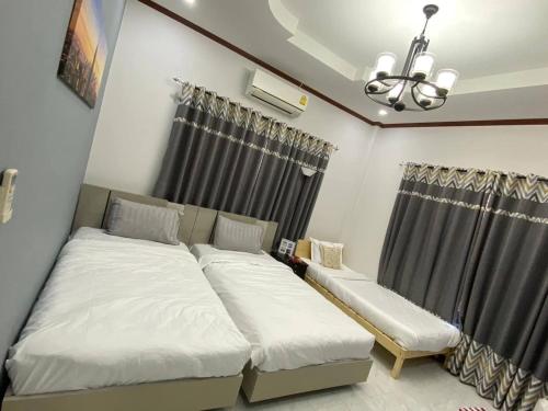 a bedroom with two beds and a window at The Natphop pool villa Meeting Pool Villa in Cha Am