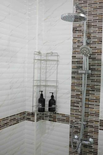 a shower with two bottles on a shelf in a bathroom at The Natphop pool villa Meeting Pool Villa in Cha Am