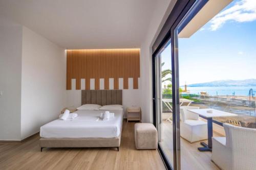 a bedroom with a bed and a view of the ocean at Azure Bay Resort in Sarandë