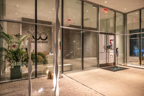 a large glass building with a potted plant in front of it at @ Marbella Lane - Luxury Beachside 2BR in Long Beach