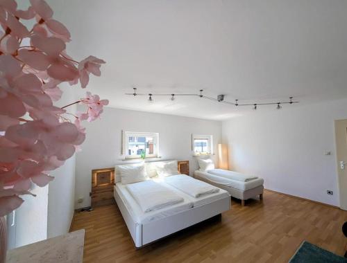 a white bedroom with a bed and a couch at Apartment Kadenbach in Kadenbach