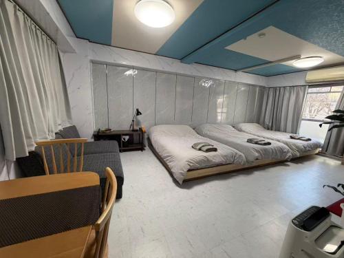 a bedroom with two beds and a table and chairs at 和風客棧 in Tokyo