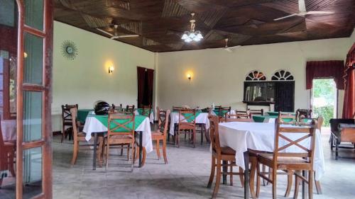a dining room with tables and chairs and a ceiling at Hansika Guest Inn in Buttala