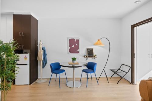 a kitchen with a table and blue chairs in a room at Central Emporium Hotel-Style 1BR with King Bed in Melbourne