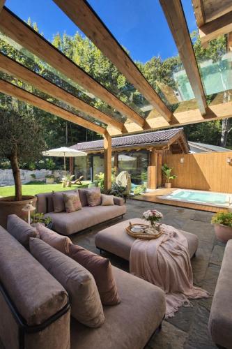 eine große Terrasse mit Sofas und einem Tisch in der Unterkunft Residence Alpi - Private Spa & Living in Grainau