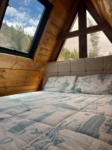 a bed in a room with a large window at Conga Lodge Cabana Alpina in La Conga