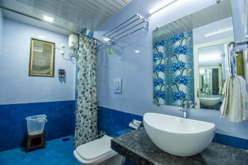 a blue bathroom with a sink and a toilet at Flora Ecostay Resort and Spa Lonavala in Lonavala