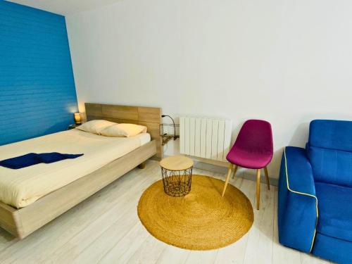 a bedroom with a bed and a red chair at Studio aux Sources de la Chabanne in Saint-Hilaire-les-Courbes