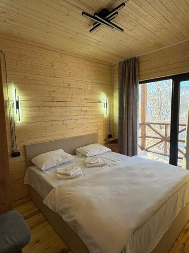a bedroom with a large bed with a ceiling fan at Old Byurakan Cottage in Byurakan